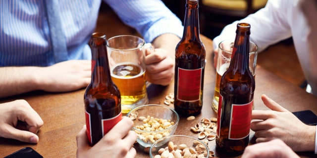 Menâs hands holding beer and pistachio