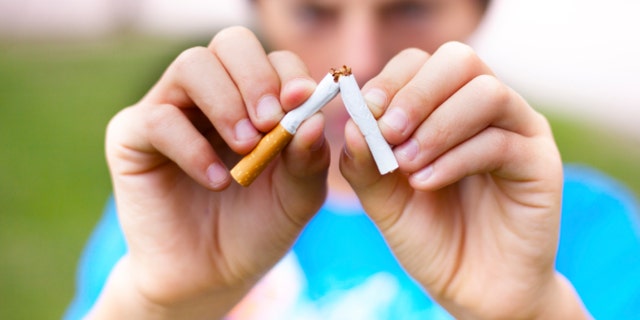 Young boy breaks a cigarette. Selective focus.