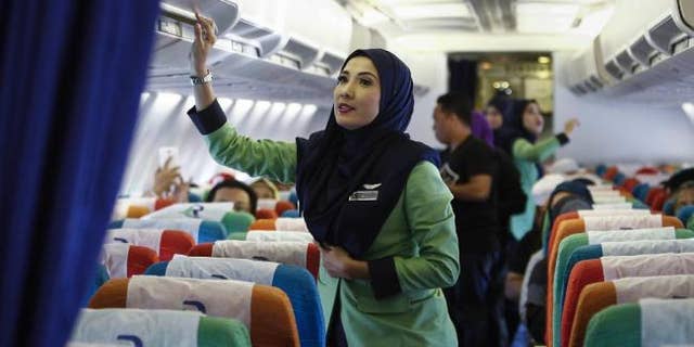 A stewardess for Rayani Air prepares the cabin for takeoff in this Dec. 22, 2015 file photo.