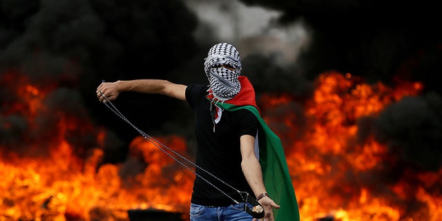 May 15, 2018: A Palestinian demonstrator holds a sling during a protest marking the 70th anniversary of Nakba, near the Jewish settlement of Beit El, near Ramallah, in the occupied West Bank.