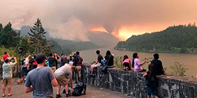 People watch the Eagle Creek wildfire burning in the Columbia River Gorge east of Portland, Ore.