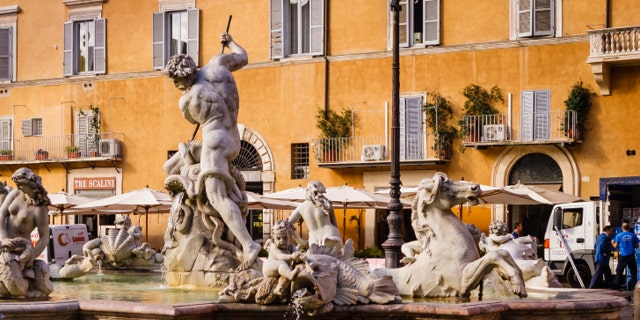 Rome, Italy - October 11, 2007: The Fountain of Neptune in Piazza Navona designed in 1574 by Giacomo Della Porta. The popular Piazza Novona in Rome, goes back to ancient Roman times when it was the site of the Stadium of Domitian which was built in the first Century AD. The Piazza was transformed into a significant example of Baroque Roman Architecture during the reign of Pope Innocent X who reigned from 1644 to 1655 AD. Today it is a very popular Roman square where many artists display their painting for sale to visitors. The photo shot in the afternoon sunlight; horizontal format.