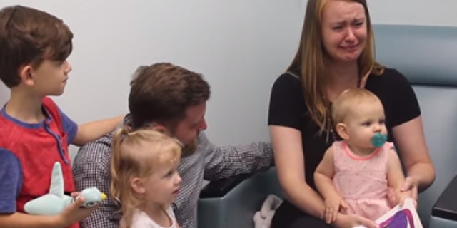Anna Esler, the mother of Ayla, could be seen holding the child on her lap at the Cook Children’s Ear, Nose and Throat hospital when the baby starts to wiggle and reach for her right ear.