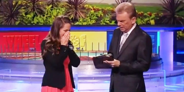 Autumn Ernhard stands beside Pat Sajack after winning $1 million on "Wheel of Fortune."