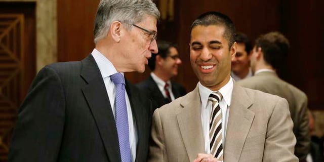 In this March 27, 2014 photo, Federal Communications Commission (FCC) Chairman Tom Wheeler, left, and FCC Commissioner Ajit Pai arrive to testify before a Senate subcommittee in Washington, D.C.