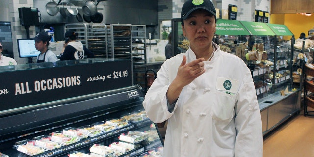 In this April 3, 2018, photo, mountain climber Lhakpa Sherpa prepares to start her shift as a dishwasher at the Whole Foods Market in West Hartford, Conn. Once a year Sherpa heads back to her native Nepal to try and break her own record for successful summits of Mount Everest by a woman.