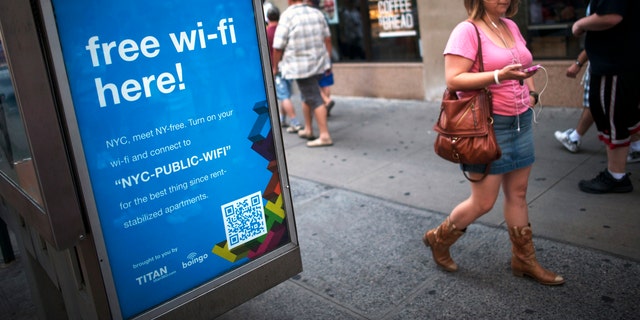 A woman walks past a WiFi-enabled phone booth in New York.
