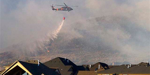 Sept. 20:  A helicopter is used to drop water on the wildfire that burns in the foothills of Herriman, Utah. A wind-stoked wildfire sparked at a firing range during a National Guard training session blazed across thousands of acres Monday as crews rushed to keep it from burning more than four homes that were destroyed overnight. The fire moved back on itself Monday as the Utah National Guard acknowledged it wasn't the first time that live-fire exercises had sparked a fire at Camp Williams, a sprawling compound 30 miles south of Salt Lake City.