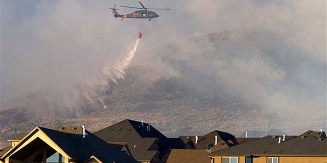 Sept. 20: A helicopter is used to drop water on the wildfire that burns in the foothills of Herriman, Utah. A wind-stoked wildfire sparked at a firing range during a National Guard training session blazed across thousands of acres Monday as crews rushed to keep it from burning more than four homes that were destroyed overnight. The fire moved back on itself Monday as the Utah National Guard acknowledged it wasn't the first time that live-fire exercises had sparked a fire at Camp Williams, a sprawling compound 30 miles south of Salt Lake City.