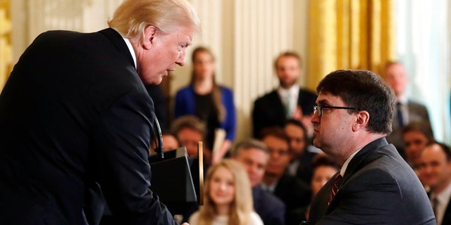 President Donald Trump shakes hands with Acting Veterans Affairs Secretary Robert Wilkie, during an event on prison reform in the East Room of the White House, Friday, May 18, 2018, in Washington. Trump announced he's nominating Acting Veterans Affairs Secretary Robert Wilkie to lead the agency.