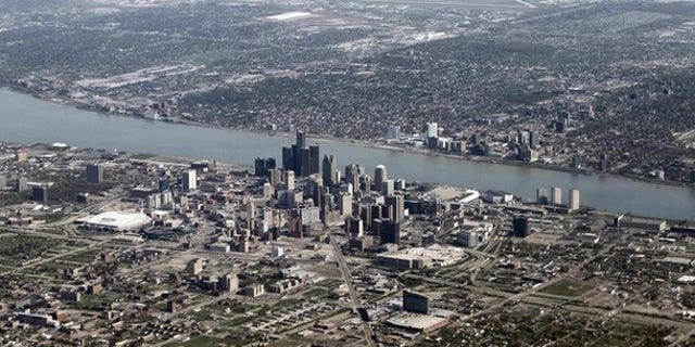 An aerial view of Detroit, Mich., seen in the foreground, while Windsor, Ontario lies on the opposite side of the Detroit River.
