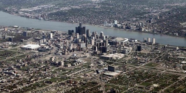 An aerial view of Detroit, Mich., seen in the foreground, while Windsor, Ontario lies on the opposite side of the Detroit River.