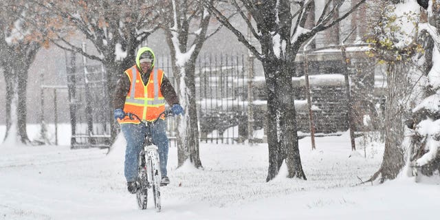 Jacinto L. Santos makes his way through the snow on his bicycle in Detroit, Sunday, Dec. 11, 2016. Santos, originally from Texas, said his mountain bike is his main mode of transportation to work and everywhere. Much of Michigan's southern Lower Peninsula, from Lake Michigan to Lake Huron, is under a winter storm warning. (Robin Buckson/Detroit News via AP)