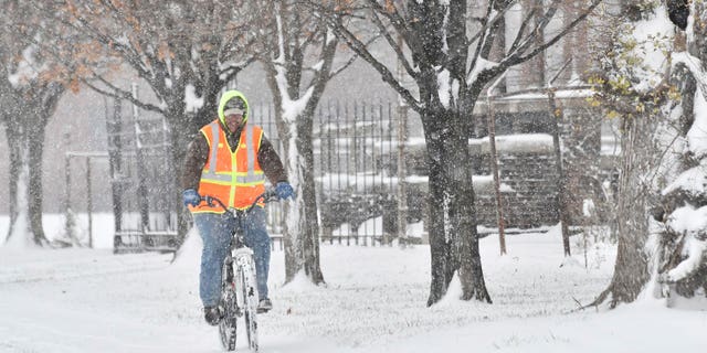 Jacinto L. Santos makes his way through the snow on his bicycle in Detroit, Sunday, Dec. 11, 2016. Santos, originally from Texas, said his mountain bike is his main mode of transportation to work and everywhere. Much of Michigan's southern Lower Peninsula, from Lake Michigan to Lake Huron, is under a winter storm warning. (Robin Buckson/Detroit News via AP)