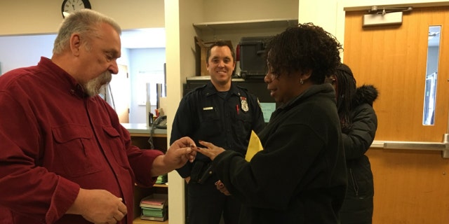 Milwaukee Police Officer Jason Schneider, center, and his father, left, helped a woman find her diamond wedding ring after she lost it in the snow last week.