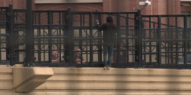 The man was moving along the fence over Interstate 43 in downtown Milwaukee.