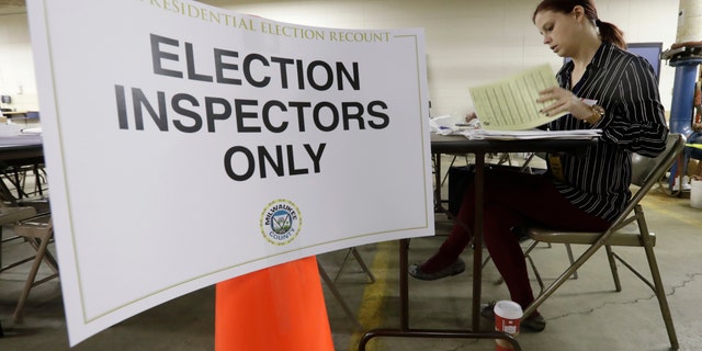 Nicole Kirby looks over results during a statewide presidential recount in Wisconsin