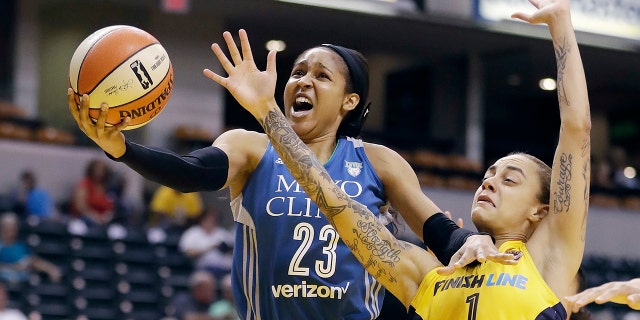 Minnesota Lynx's Maya Moore, left, shoots against Indiana Fever's Jazmon Gwathmey during the first half of a WNBA basketball game in Indianapolis.