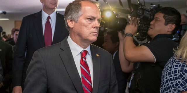 In this June 8, 2017 file photo, James Wolfe, center, former director of security with the Senate Intelligence Committee, escorts former FBI director James Comey to a secure room to continue his testimony on the 2016 election and his firing by President Donald Trump, on Capitol Hill in Washington.
