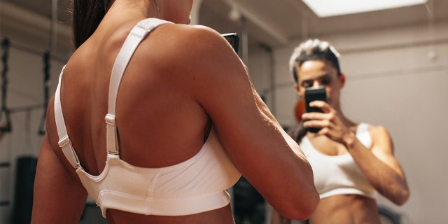 woman taking pic in gym istock