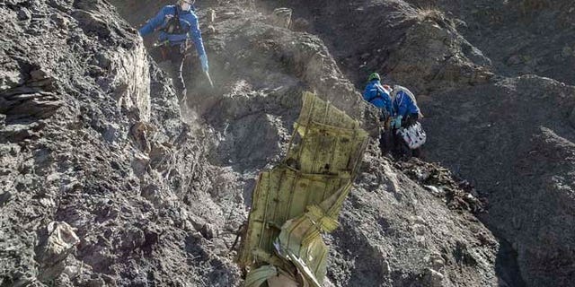 In this photo provided April 3, 2015 by the French Interior Ministry, French emergency rescue services work among debris of the Germanwings passenger jet at the crash site near Seyne-les-Alpes, France.