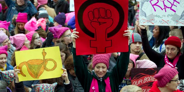 Jan. 21, 2017: Women with bright pink hats and signs gather early and are set to make their voices heard on the first full day of Donald Trump's presidency.