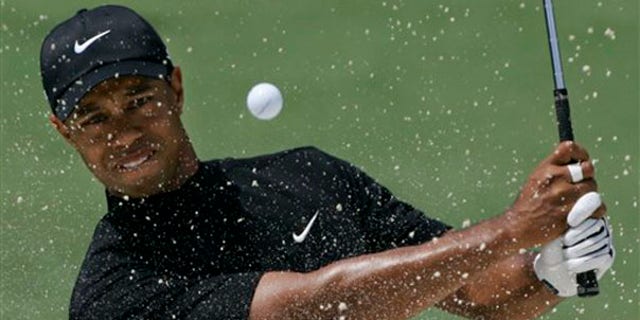 In this April 11, 2008, file photo, Tiger Woods hits out of a bunker on the second hole at the Augusta National Golf Club. (AP Photo)