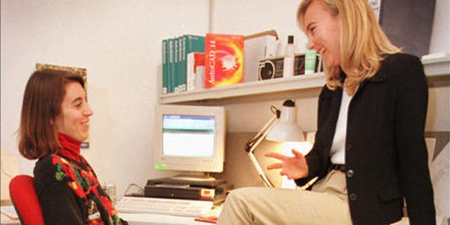 Autodesk employees Jackie Pierce, right, and Nancy Murray talk at work while Norby, the golden labrador, sleeps Dec. 17, 1997, in San Rafael, Calif. The relaxation of work rules, such as allowing a pet to accompany an employee to work, is attracting workers to more flexible companies like Autodesk. (AP Photo/Ben Margot)