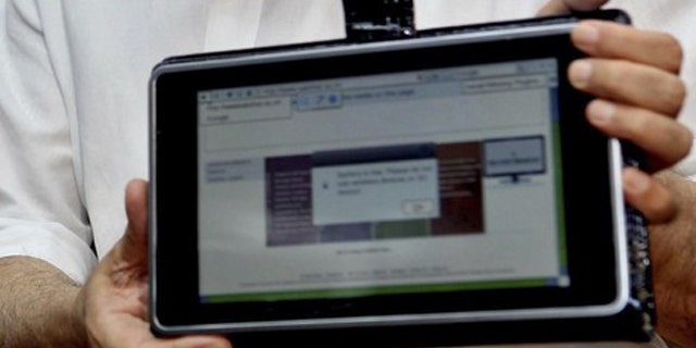 India's Human Resource Development Minister Kapil Sibal displays the low-cost computing device during its unveiling in New Delhi July 22, 2010. India has come up with the world's cheapest "laptop," a touch-screen computing device that costs $35. Human Resource Development Minister Kapil Sibal this week unveiled the low-cost computing device that is designed for students, saying his department had started talks with global manufacturers to start mass production. Picture taken July 22, 2010.