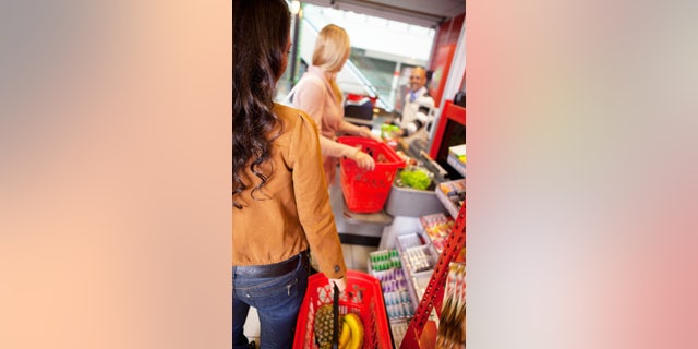 Customers carrying basket while shopping in supermarket