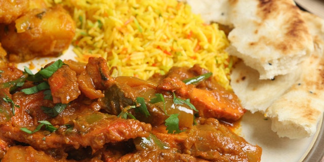 Indisches Hühner-Jalfrezi mit Bombay Aloo, Pilau-Reis und Naan-Brot.