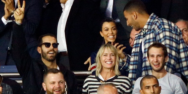 Wright and Giraudet are rumored to have been together since May 2017. Here the two cheer on soccer players at a Paris match with Wright's son, Hopper Jack Penn.
