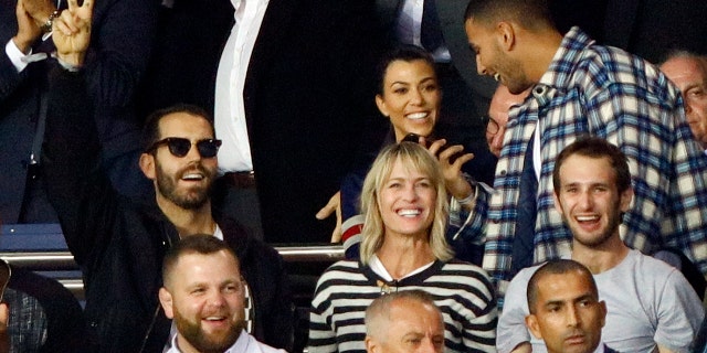 Wright and Giraudet are rumored to have been together since May 2017. Here the two cheer on soccer players at a Paris match with Wright's son, Hopper Jack Penn.