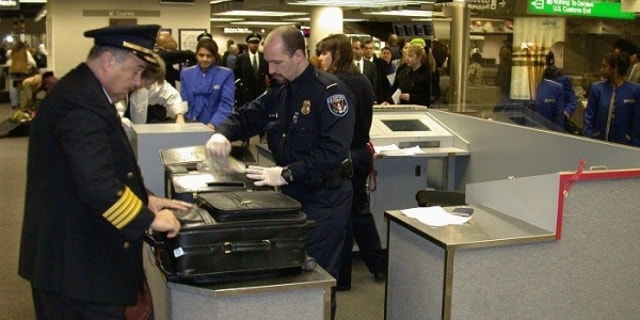 Customs agents inspect airline passenger bags at New York's John F. Kennedy Airport.