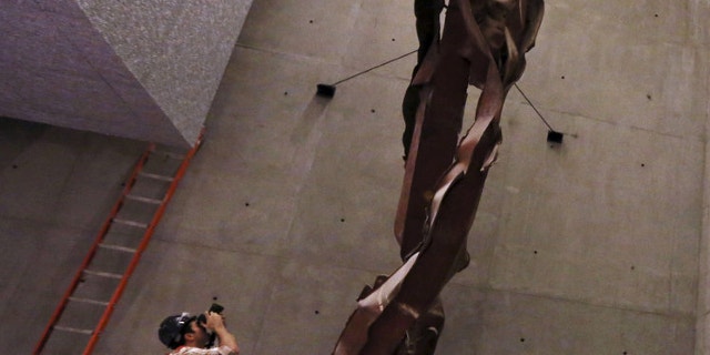 FILE: Sept. 6, 2013: A photographer take a picture of steel column from the North Tower of the World Trade Center during a media tour of the National September 11 Memorial and Museum in New York. Some museum workers reportedly say they see a face in the metal.