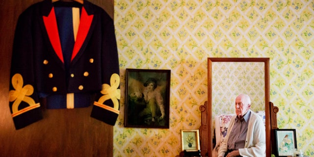 Frank Gleason, 96, a retired colonel with the Office of Strategic Services, looks at his old blue mess dress uniform hanging on a door as he sits in his home in Atlanta, Wednesday, Sept. 28, 2016.