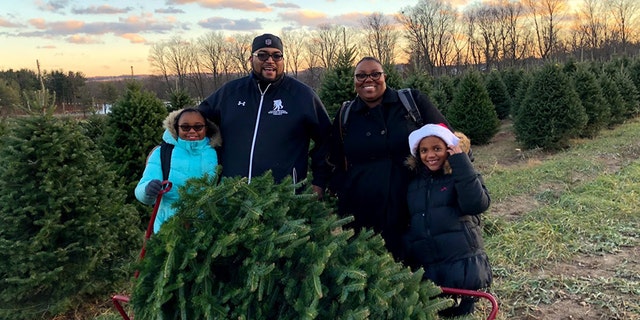 A family cuts down their own tree as part of the Wounded Warrior Project holiday event at the Pine Tree Barn in Wooster, Ohio.