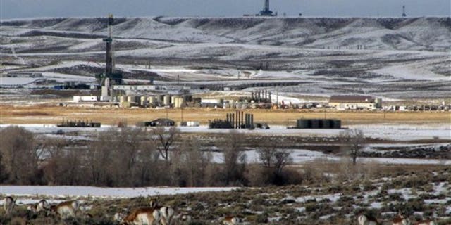 In this Jan. 22, 2010 photo, antelope graze not far from gas drilling rigs in western Wyoming's Upper Green River Basin, where ozone levels last week exceeded the worst days in major U.S. cities last year. (AP Photo/Mead Gruver)