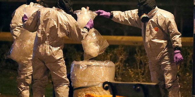Soldiers in protective gear investigate the poisoning of a former Russian spy and his daughter in Britain.
