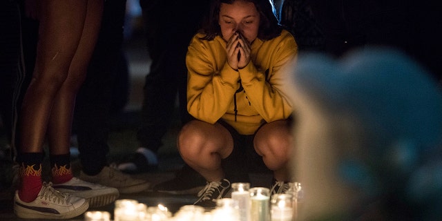 In this Tuesday, June 19, 2018 photo, fans and community members gather at the vigil for rap singer XXXTentacion in Deerfield Beach, Fla., near the site where the troubled rapper-singer was killed the day before.