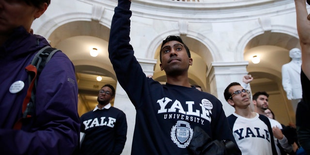 Yale student Jishian Ravinthiran, center, raises his fist during a protest against Judge Brett Kavanaugh in the Russell Senate Office Building Rotunda, on Capitol Hill, Monday, Sept. 24, 2018, in Washington.