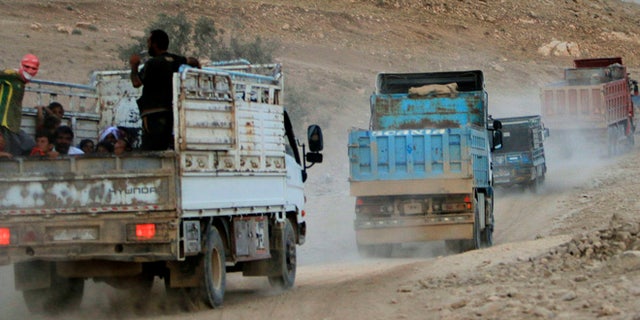 August 13, 2014: Displaced people from the Yazidi religious minority, fleeing violence from forces loyal to the Islamic State in Sinjar town, ride trucks as they are evacuated from Mount Sinjar in northern Iraq with the help of members of the Kurdish People's Protection Units (YPG), as they make their way towards Newrooz camp in Syria's al-Hasakah province.