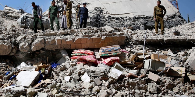 Jan. 18, 2016: Policemen gather at the site of a Saudi-led airstrike on the police headquarters in Sanaa, Yemen.