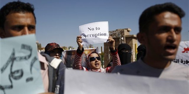 Yemeni demonstrators hold placards during an anti-government protest in Sanaa, Yemen, Feb. 10.