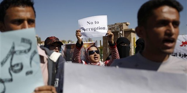 Yemeni demonstrators hold placards during an anti-government protest in Sanaa, Yemen, Feb. 10.