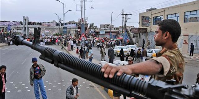 May 25: A Yemeni army soldier stands guard at a checkpoint in Sanaa, Yemen. Yemen's embattled President Ali Abdullah Saleh issued messages of hard-line defiance Wednesday even as intense battles raged in the heart of the capital for a third day, saying he will not step down or allow the country to become a "failed state." (AP)