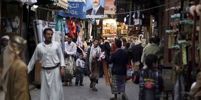 Aug. 9: People walk past vendors selling goods, beneath a poster showing Yemen's President Ali Abdullah Saleh, in a street leading to the old city of Sanaa, Yemen. The U.S. and Saudi Arabia pressured Yemen's president Ali Abdullah Saleh to stay in Saudi Arabia after he was released from a lengthy hospital stay to treat wounds suffered in an assassination attempt, according to Yemeni officials.