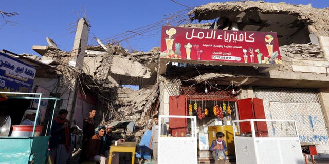 Sana'a. A young man in his food store, located in a destroyed building.