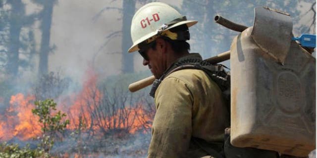 Aug. 30, 2013: A member of the Monterey Hotshots carries a gas can near a burn operation on the southern flank of the Rim Fire near Yosemite National Park in California.
