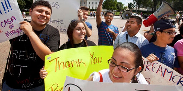 FILE - In this June 15, 2012 file photo, young demonstrators participate in a rally in support of President Barack Obama after the president announced that the U.S. government will stop deporting and begin granting work permits to younger illegal immigrants who came to the U.S. as children and have since led law-abiding lives. Young Hispanic and Asian-Americans who are immigrants themselves or have a parent who is are more likely to be liberal in their views on politics and immigration than those with families who have been in United States longer, a new GenForward poll shows. (AP Photo/Jacquelyn Martin, File)